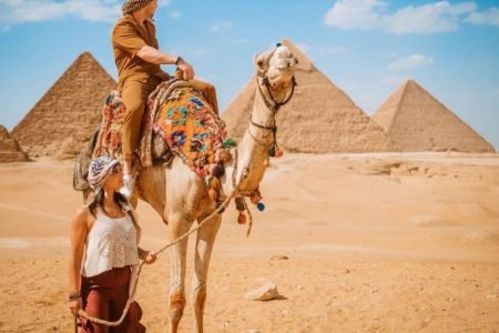 a man and woman with a camel in the pyramids area