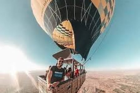 a group of people in a hot air balloon above valley of the kings